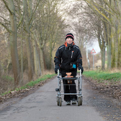 seniorin mit rollator auf einem weg