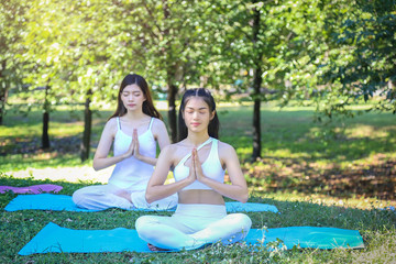 Couple woman friend practice yoga in the park