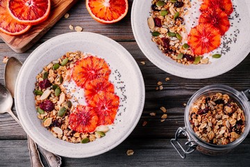 healthy breakfast bowl of homemade granola with fresh yogurt and blood slices oranges