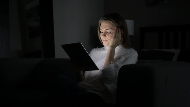 Tired Woman with Headache using Tablet at Night