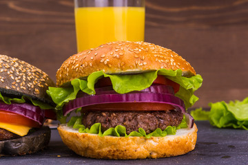 Delicious homemade hamburger on a bun with sesame and a glass of juice