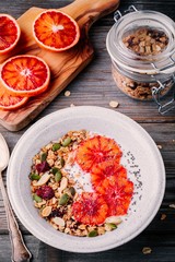 healthy breakfast bowl of homemade granola with fresh yogurt and blood slices oranges