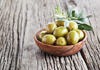 Green olives on wooden board