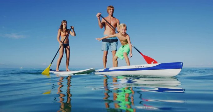 Family stand up paddle boarding in the ocean, active lifestyle