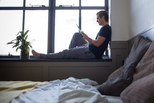 Young male reading on digital tablet