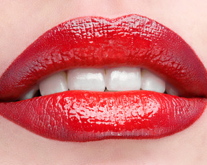 Obraz premium The female lips which are made up by red lipstick.