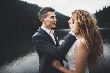 Perfect couple bride, groom posing and kissing in their wedding day