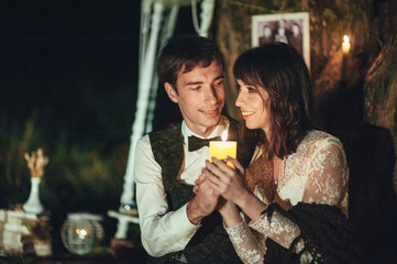 pretty caucasian engaged couple hugging beside tree with lantern