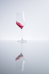 Rotweinglas auf spiegelnder Oberfläche
