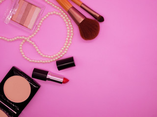 Flat lay cosmetics and accessories on pink background