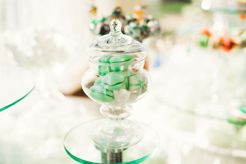 Delicious and tasty dessert table with cupcakes shots at reception closeup