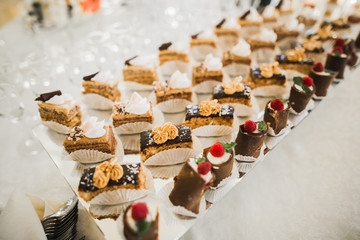 Delicious sweets on wedding candy buffet with desserts, cupcakes