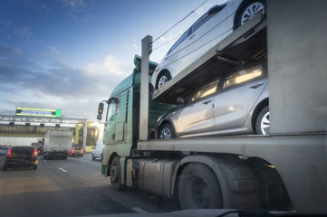 The trailer transports cars on the highway