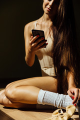 Beautiful modern ballet dancer with perfect body holds a cell phone in his hand. Type message.