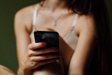 Beautiful modern ballet dancer with perfect body holds a cell phone in his hand. Type message.