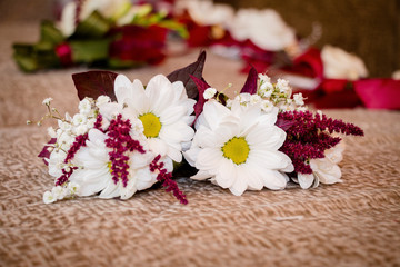 Obraz na płótnie Canvas Wedding boutonier for the charming bride. In a bouquet used chamomile and cute red leaves