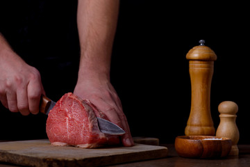 Man cutting beef meat on kitchen