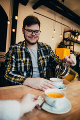 man fill up cup with hot tea