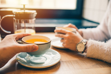 couple drink orange tea in cafe together