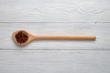 Anise spice in a wooden spoon on a white background