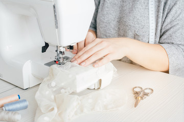Obraz na płótnie Canvas Young seamstress working on sewing machine