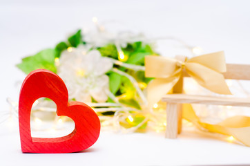 wooden heart with a bow on a bench on a white background. Valentine's Day