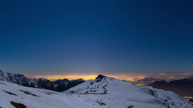 Turin city lights, panoramic night view from snow covered Alps by moonlight with clear sky. Italy.