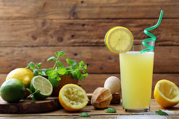 succo di limone e lime in bicchiere su sfondo tavolo legno