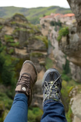 Two women shows their feet hing in the mountains, hiking in meteora