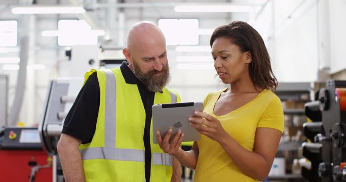 4K Female business manager in printing factory giving instructions to an employee. Slow motion.