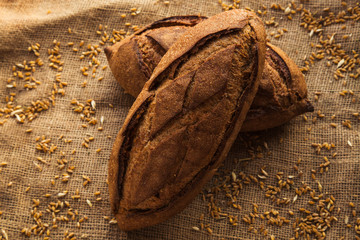 Loaf of homemade bread on sackcloth with rye.