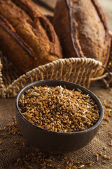 Bowl full of rye on sackcloth with loaf of bread.