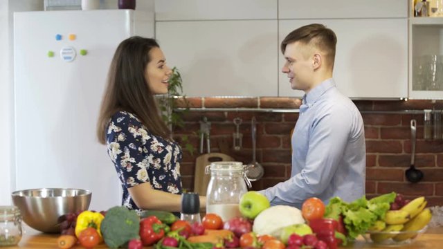 Attractive young couple cooking and chatting in Kitchen