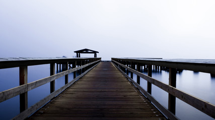 Fototapeta na wymiar A beautiful pier in the middle of a foggy lake 