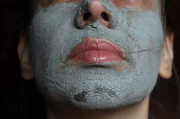 Mud facial mask of woman