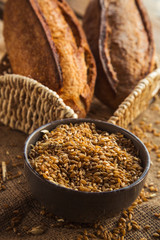 Bowl full of rye on sackcloth with loaf of bread.