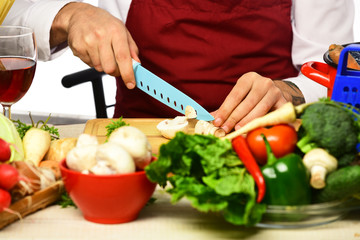 Cooking process concept. Male hands cut mushroom with knife