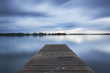 The jetty at the Valkenburg lake on a cloudy evening.