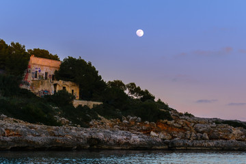 Old house in ruins under the light of the moon