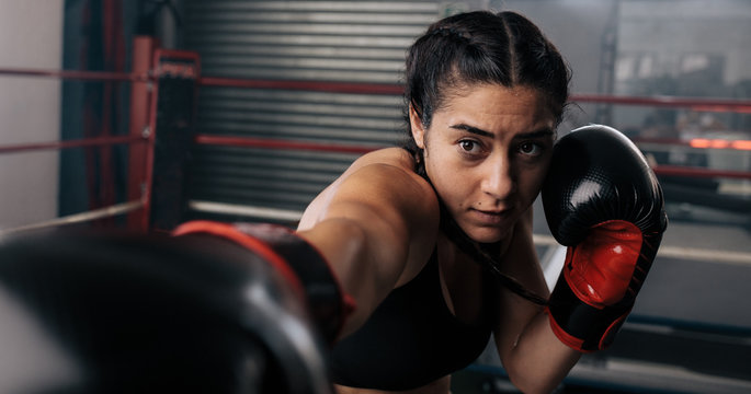Female boxer training inside a boxing ring