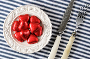 red hearts on a plate and a knife with a fork