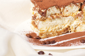 Cake tiramisu with an image of a fork on a plate sprinkled with chocolate
