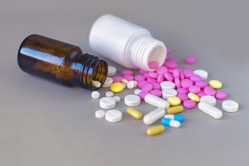 Composition of medicine bottles and pills on gray background.