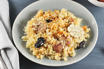 Oriental dish - plov with prunes, carrots, garlic