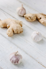 Garlic and ginger on white wooden surface.