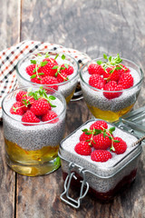 Chia  seed puddings with orange marmalade and raspberries on wooden table