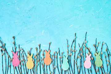 Easter background. Willow branch with Easter decoration on blue background. Copy space, top view.