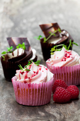 Chocolate  cupcakes with fresh raspberries and cream on wooden table