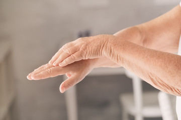 Hands of senior woman with healthy skin softened by cream with moisturizing effect