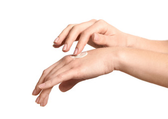 Young woman applying hand cream, on white background